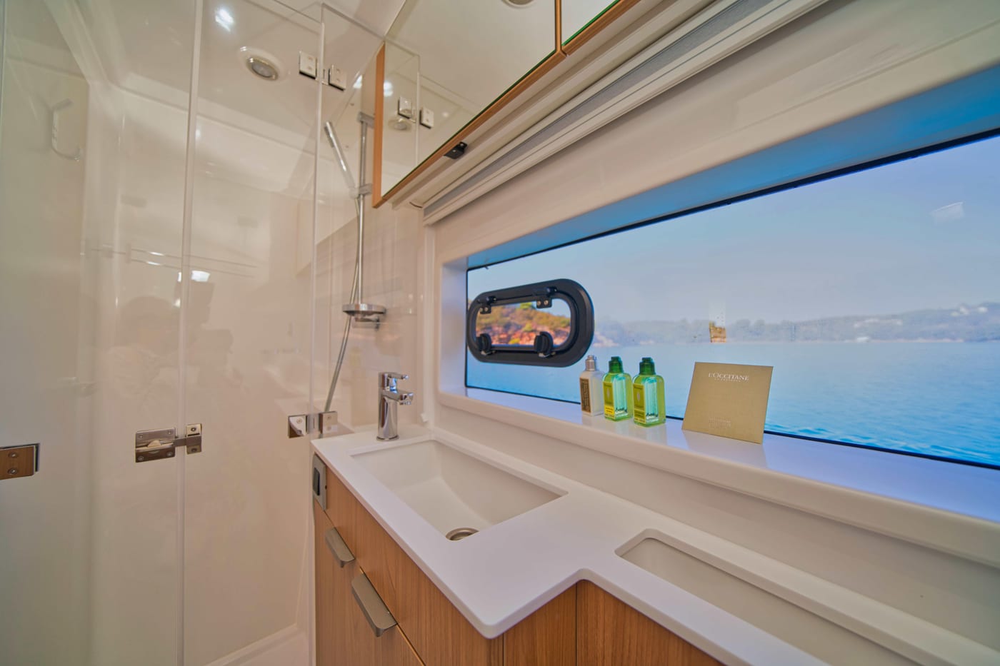 Bagno di bordo con doccia, lavabo e oblò vista mare